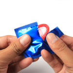 Man's Hands Unwrapping a Condom