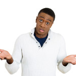 Closeup portrait of dumb clueless young man, arms out asking why what's the problem who cares so what, I don't know. Isolated on white background. Negative human emotion facial expression feelings