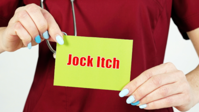 A person holding a Jock Itch sign